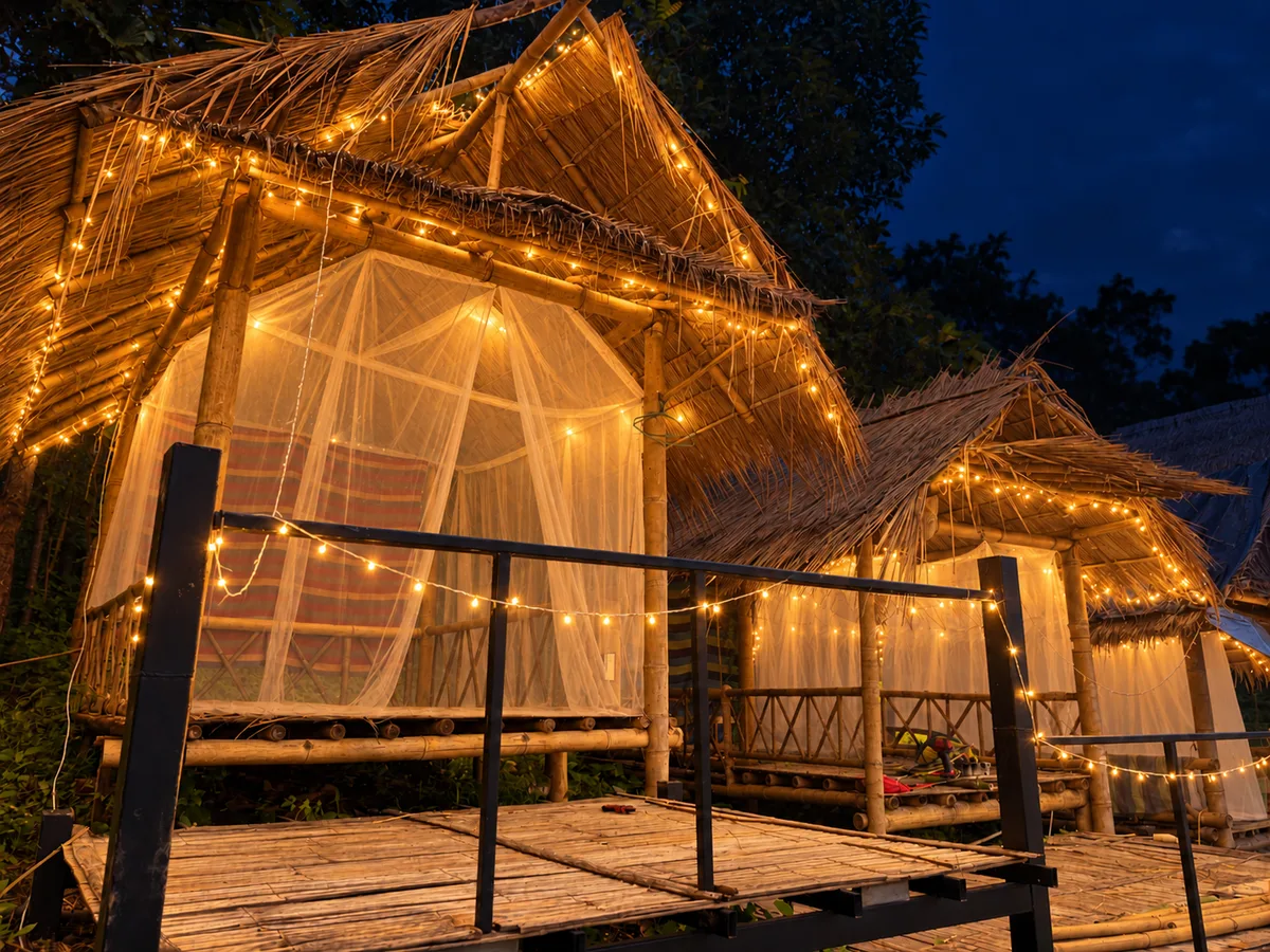 An open-air bamboo bungalow glowing with warm string lights at Bungalows & Bunks in Pai.